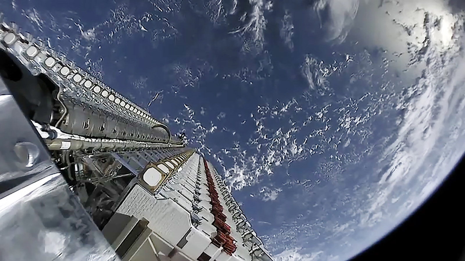 SpaceX Starlink satellites waiting to be launched into orbit with Earth in the background