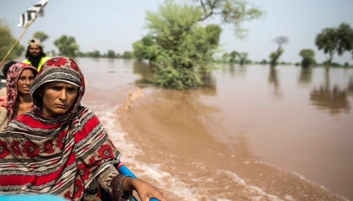A flood victim sits on a boat as she is evacuated from her flooded house following heavy rain in Jhang, Punjab province, September 10, 2014. - Reuters