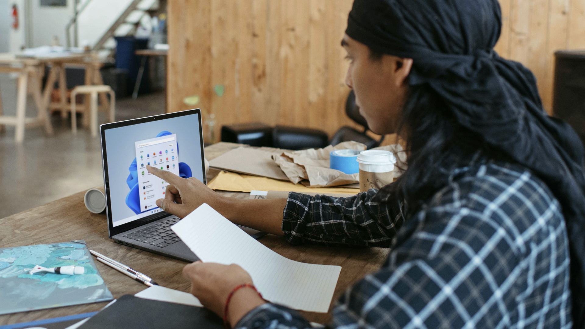 A person using a touchscreen laptop with Windows 11.