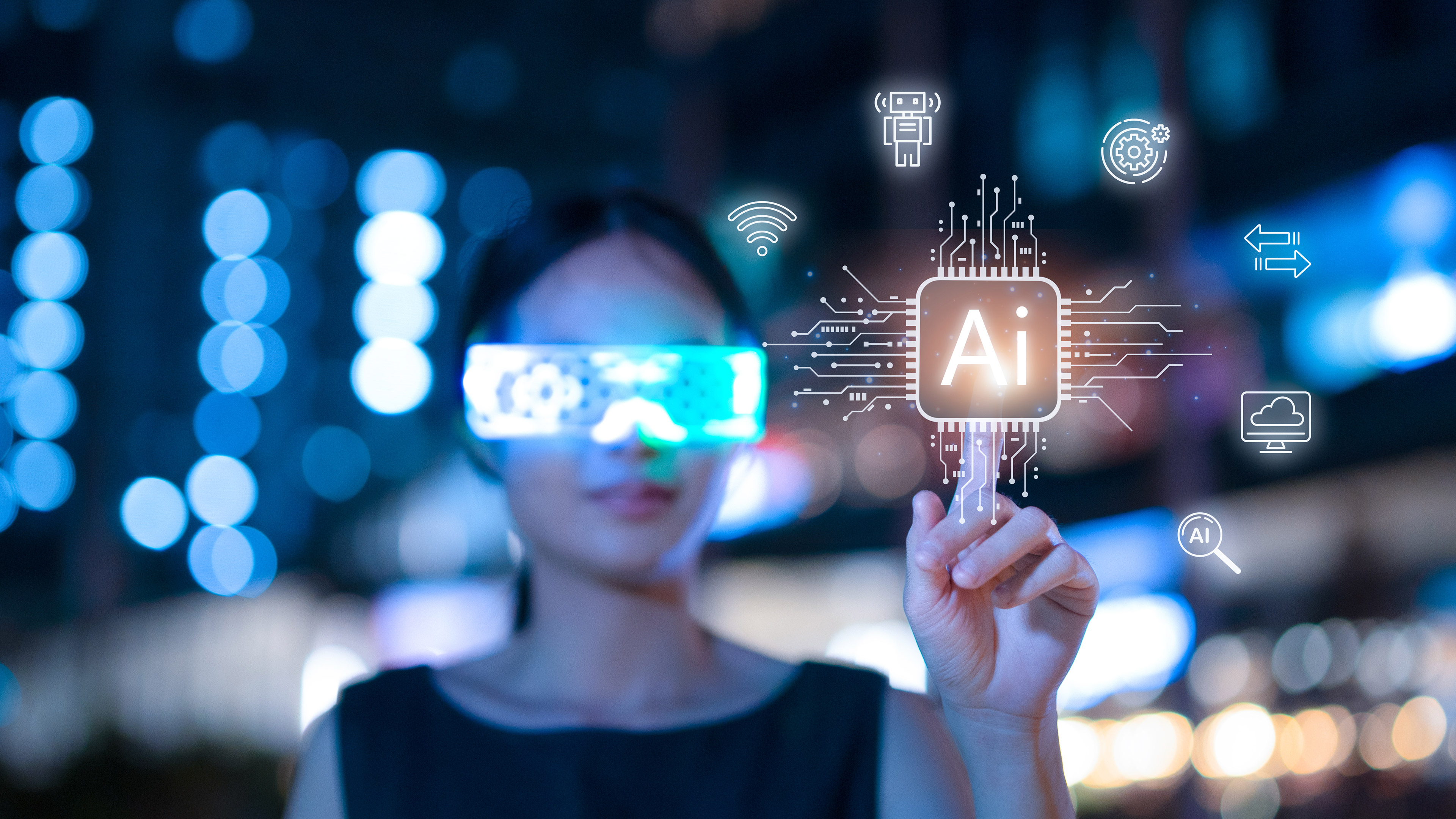 An out-of-focus woman in the background touches the word AI, illuminated with a bright yellow light, in the foreground. The woman is wearing smart glasses.