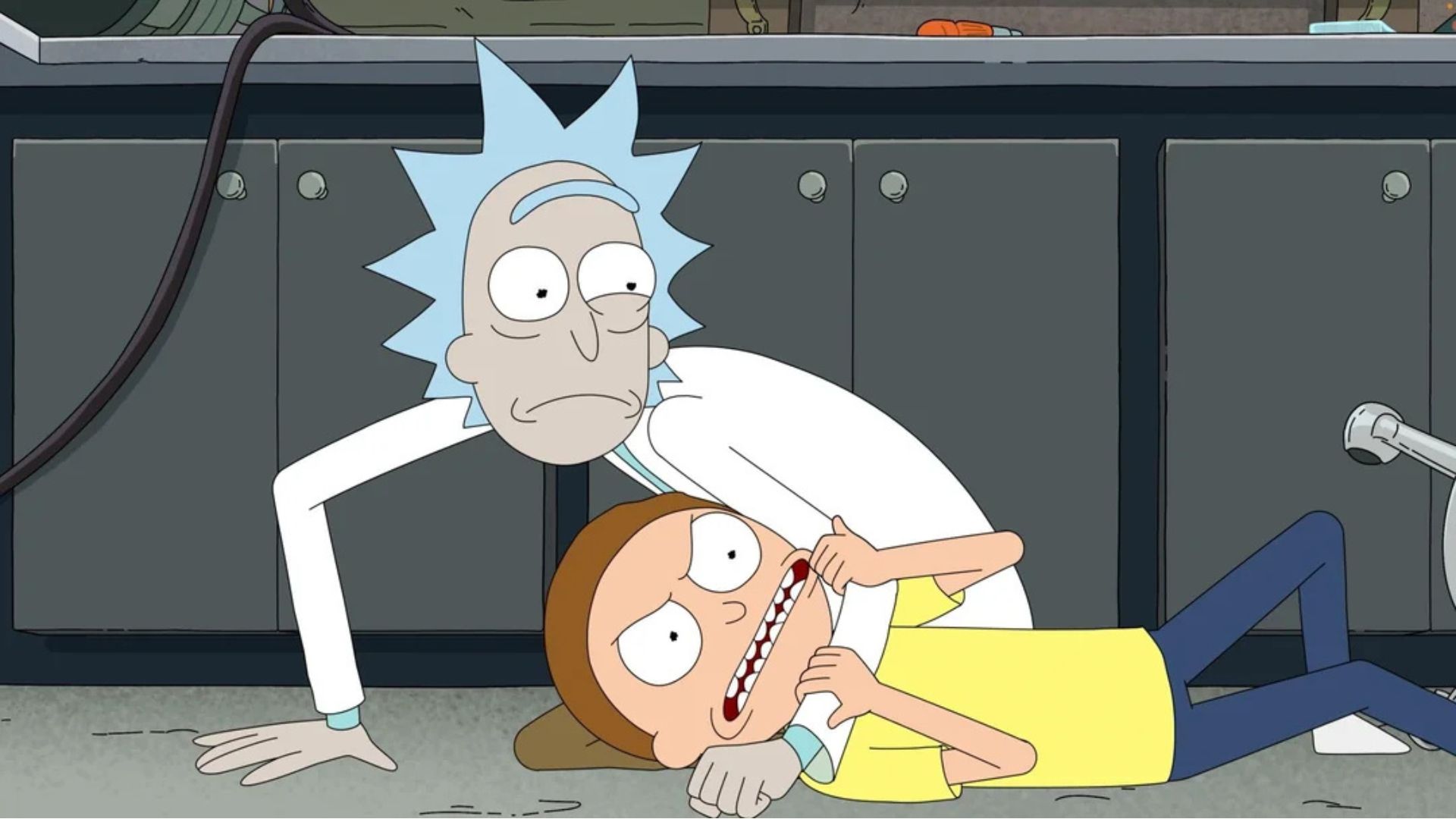Rick has Morty on the floor in a headlock.
