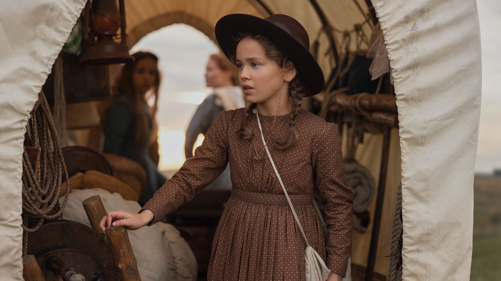Laura is in the back of a wagon.