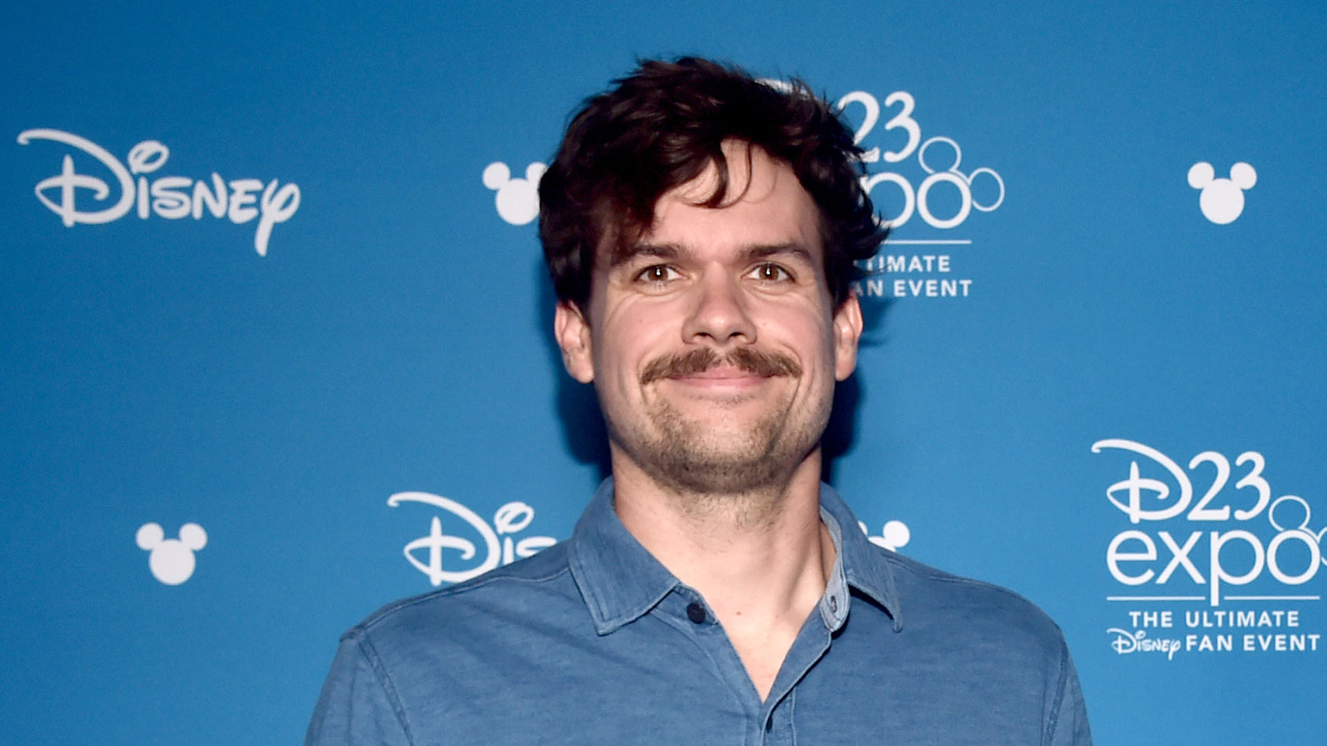 Michael Waldron smiles as he poses for photos at the D23 Expo