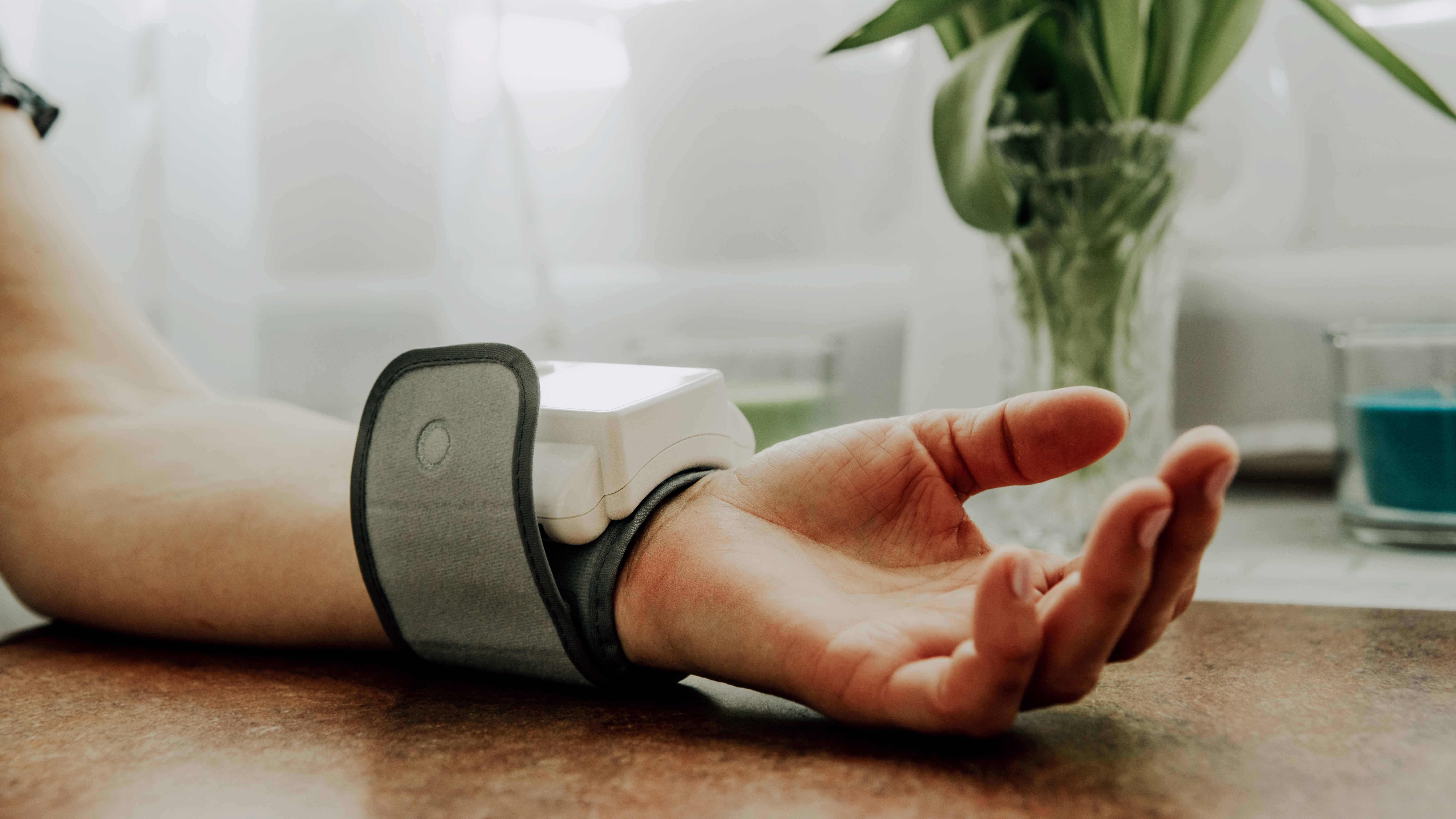 Person's wrist, with blood pressure cuff.