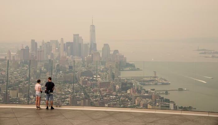 People visit the Edge observation deck as the New York City skyline and One World Trade Center are seen through a blanket of wildfire smoke in New York City, U.S., July 16, 2026. – Reuters