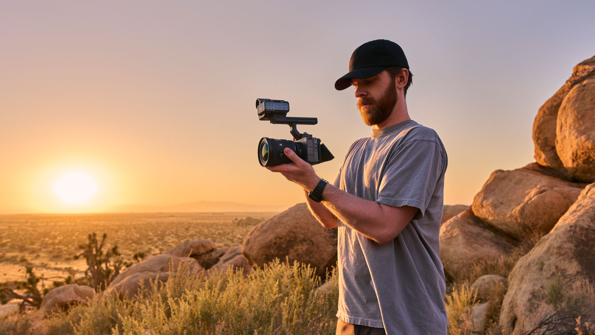 Sony FX5 with attached top handle, held by a camcorder in an arid outdoor landscape at golden hour