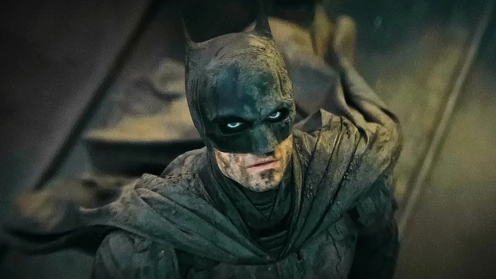 Robert Pattinson's mud-covered masked crusader looking up in The Batman
