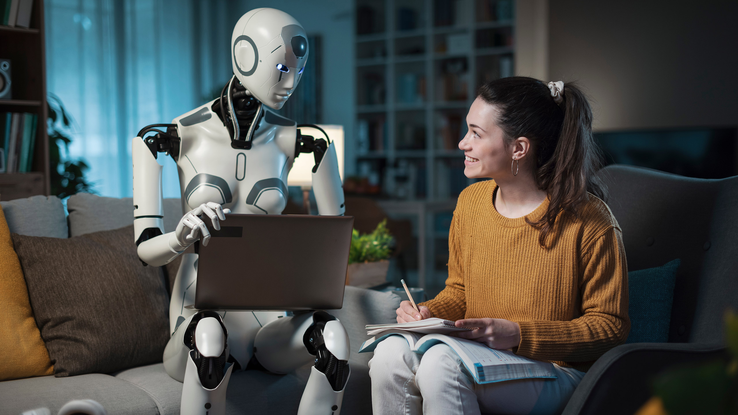 With an AI android at her side, a young woman studies on a sofa in her modern home, highlighting the benefits of artificial intelligence.