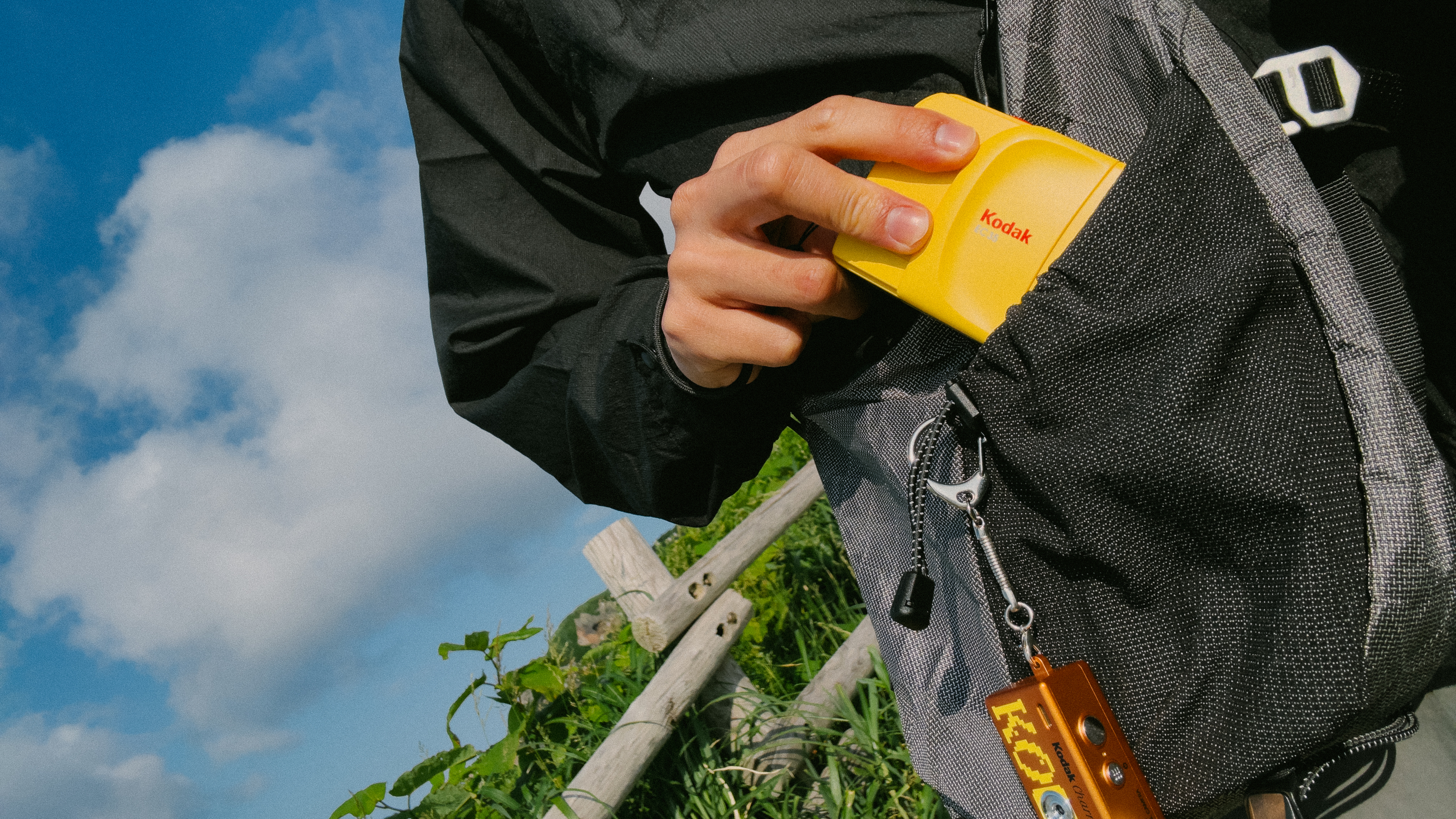 Photograph of Kodak EC35 film camera placed inside a backpack outdoors