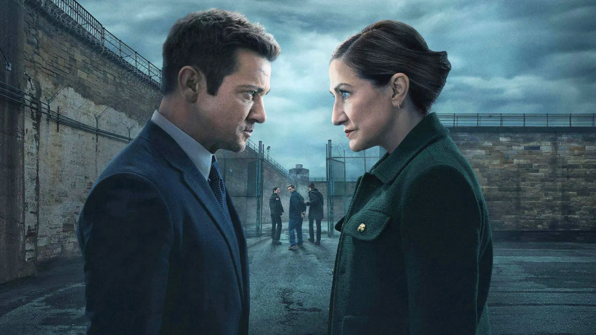 A man and a woman look at each other outside the prison doors.