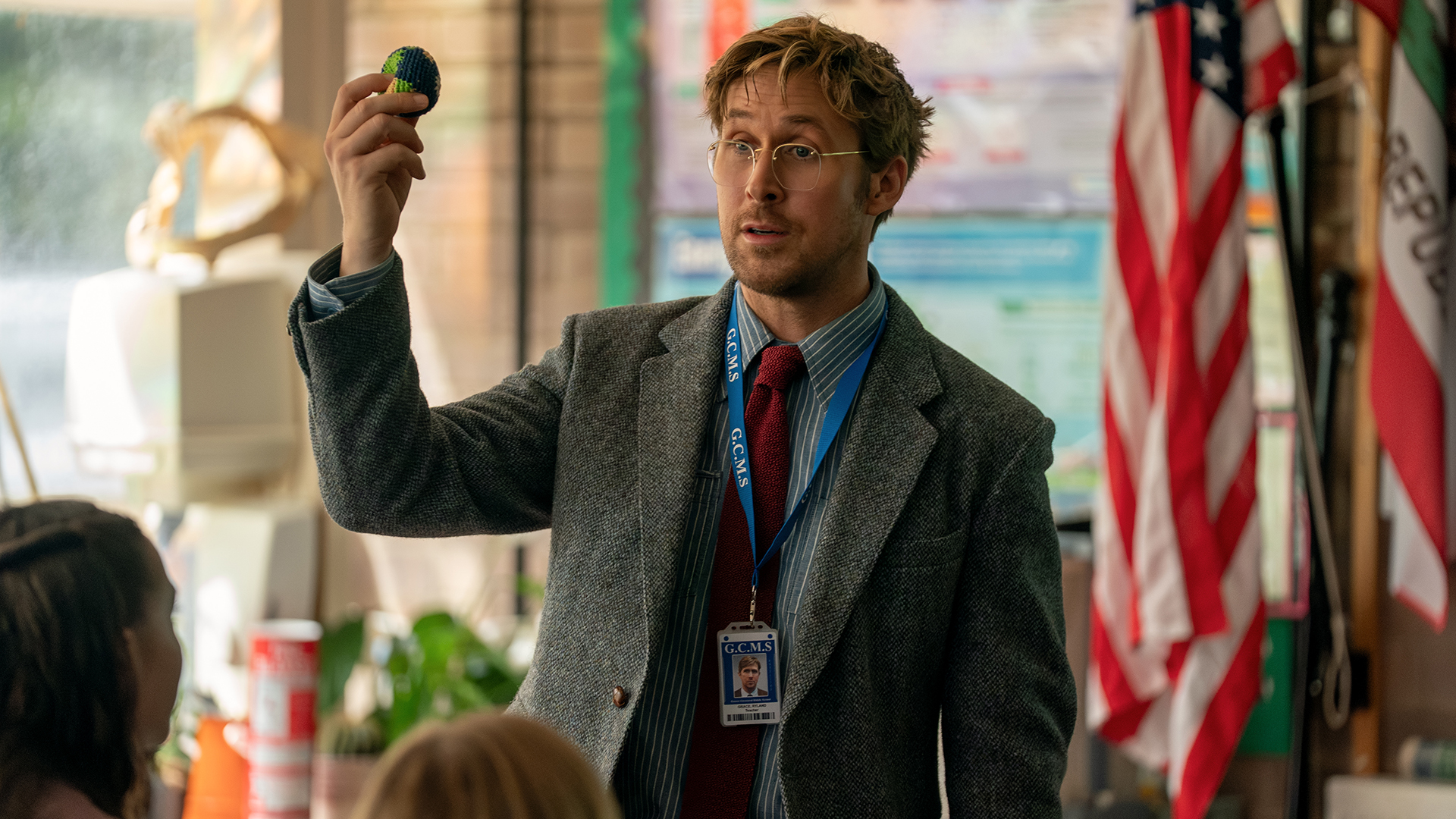 Ryland Grace holding a knitted Earth in front of some school children at the Hail Mary Project