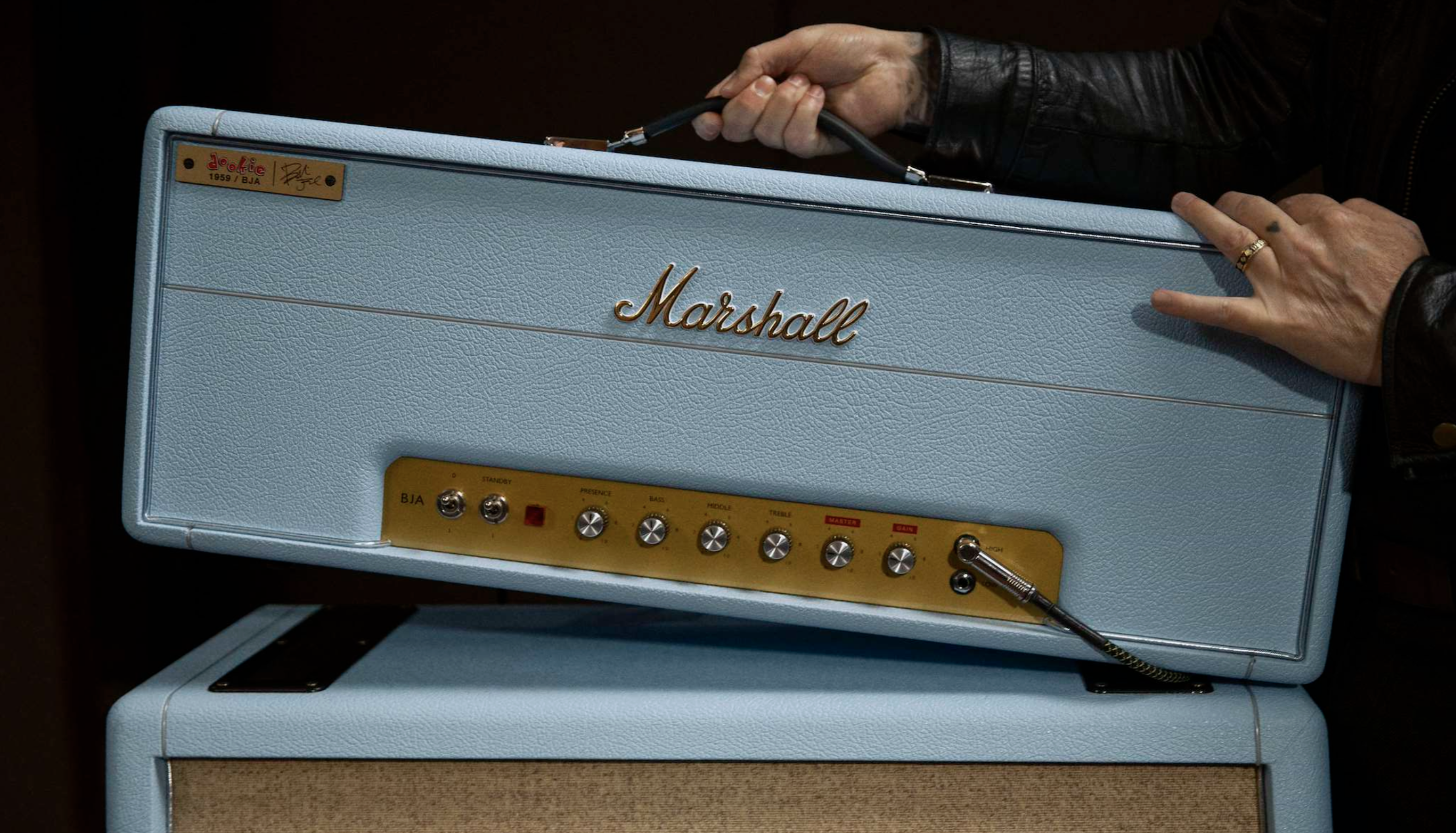The baby blue Marshall x Billie Joe Armstrong guitar amp head, held by the star, whose arms are barely visible