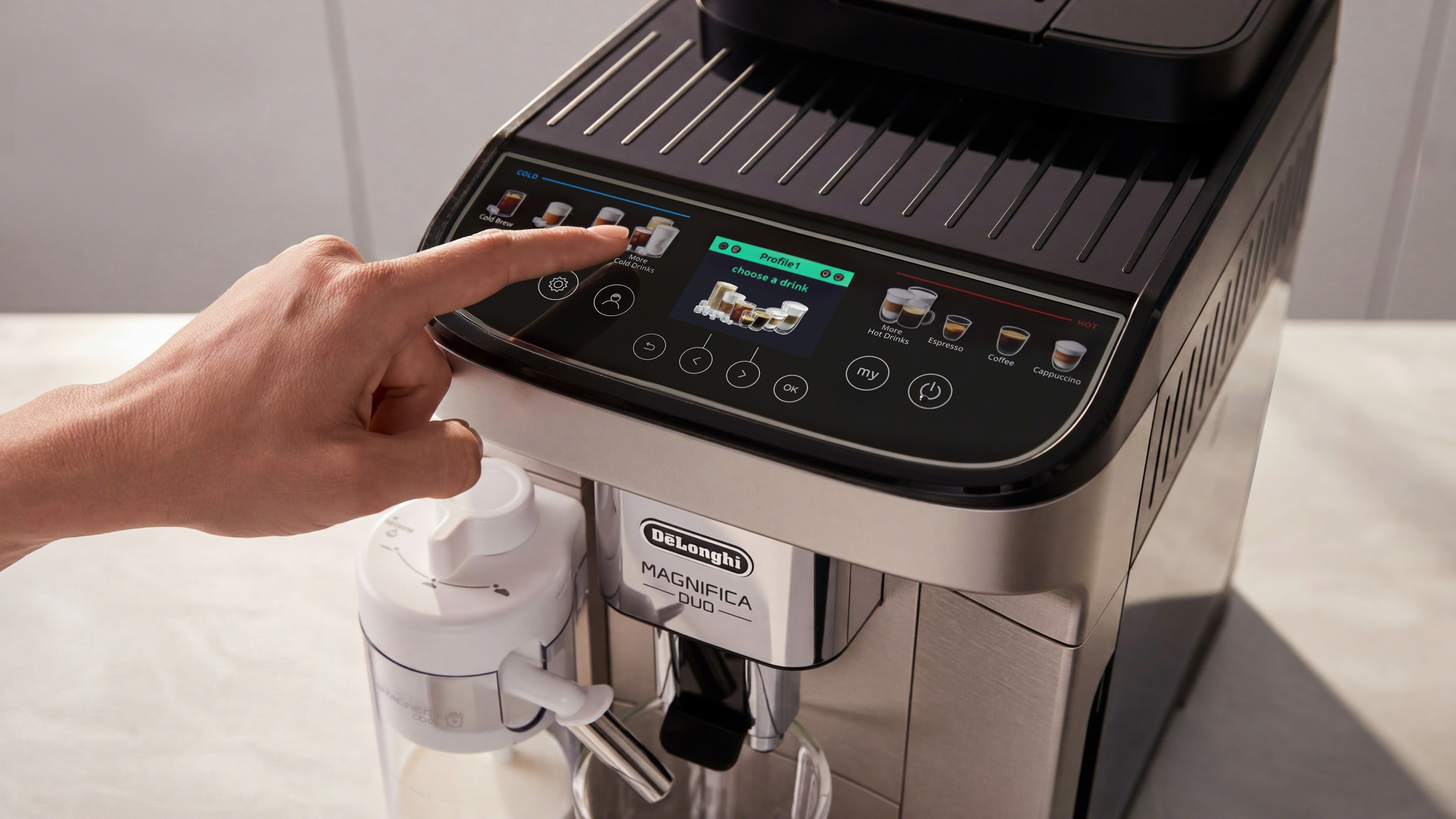 Person pressing the button of the De'Longhi Magnifica Duo coffee machine